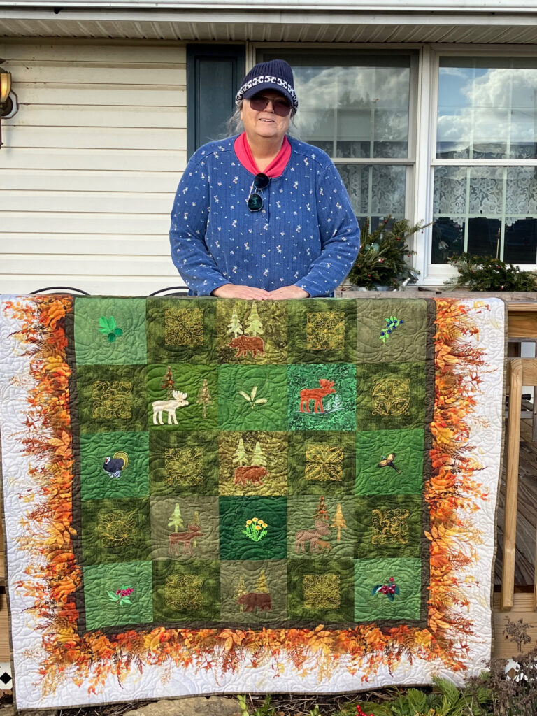 Noelle presenting her finished Bear and Moose quilt.